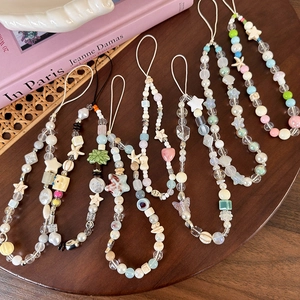 Lot de dragonnes de téléphone avec perles et étoiles de mer sur plateau en bois