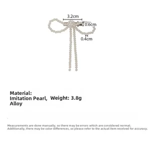 Detail view of pearl bow hair clip showing 3.2cm size measurements and alloy base