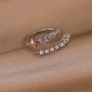Detail of adjustable silver ring featuring colorful gemstones and white pearls on silk