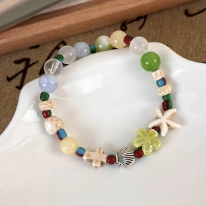 Detail of summer ocean style beaded bracelet with ceramic charms and starfish pendant