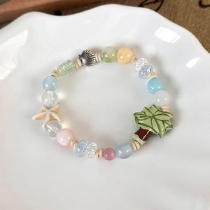 Detailed close-up of summer ocean style beaded bracelet with coconut tree and shell charms