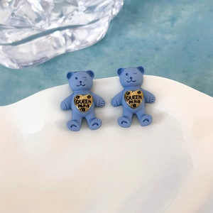 Dettaglio degli orecchini a forma di orsetto in resina blu con ciondolo a cuore dorato