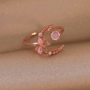 Detailed macro view of rose gold adjustable ring with pink gems and moon butterfly motifs