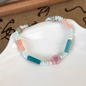 Detailed close-up of colorful ceramic beads and floral pendant on a summer ocean bracelet