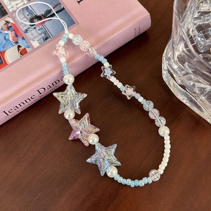 Detail of blue star beaded phone strap with iridescent stars and pearls on a desk