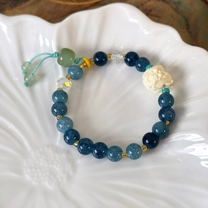 Detailed close-up of beaded lion bracelet with blue beads and adjustable tassel cord