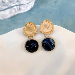 Dettaglio degli orecchini pendenti in resina blu marmo con finitura in metallo