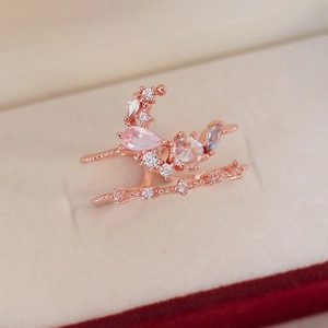 Detail of rose gold double-layered ring featuring pink pear-cut stone and zircon flowers