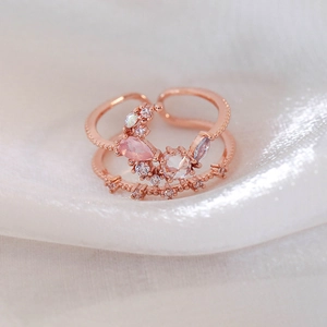 Detail of rose gold moon ring featuring pink teardrop gems and white opal zircons