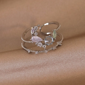 Macro detail of a double-layered adjustable ring with colorful gemstones on silk fabric
