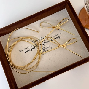 Golden minimalist bow hair clips with matching braided cord in a vintage display box