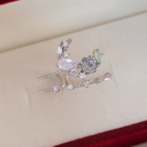 Detail of silver double-band ring with lavender, blue, and green gemstones on velvet