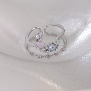 Detailed macro view of silver ring featuring a cluster of colorful zircon stones on silk