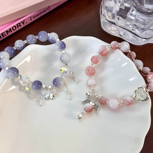 Floral butterfly and angel wing beaded bracelets with crystals and charms in a ceramic dish