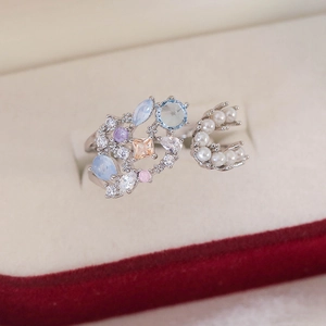 Detail of silver ring featuring colorful faceted gemstones and double rows of small white pearls