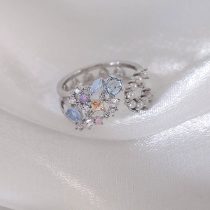 Detailed macro view of adjustable silver ring with colorful gems and pearl flower design