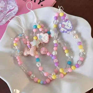 Three colorful Y2K beaded phone straps with star and bear charms in a decorative tray