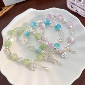 Detailed macro of three colorful candy-colored beaded bracelets with heart charms