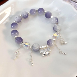 Macro shot of a floral butterfly beaded bracelet with silver tassels and purple marble beads