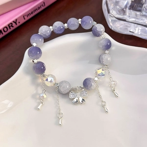 Detail of beaded floral bracelet with purple crackle beads and a silver bow pendant