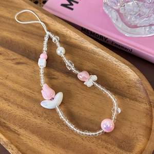 Detailed shot of pink tulip and white bow beads on a handmade phone wrist strap