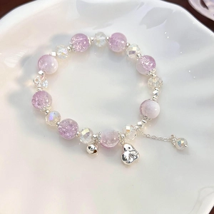 Detail of lavender crackle crystal beads and silver heart pendant on a beaded bracelet