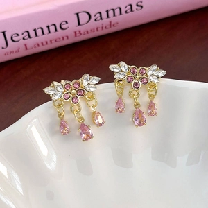 Vue macro détaillée des boucles d'oreilles fleurs roses et pampilles de zircons