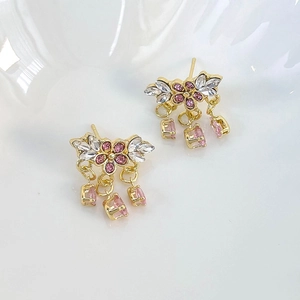 Détail de boucles d'oreilles fleurs en cristal rose avec pendentifs scintillants
