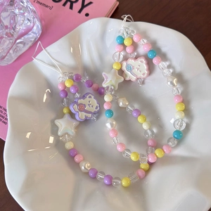 Close-up of colorful beads and star-shaped charms with a cute bear on a phone strap