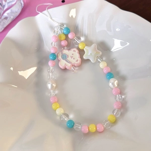 Detail of beaded phone strap with resin bear charm and colorful acrylic stars