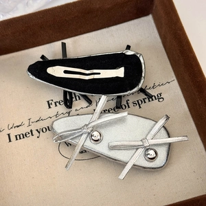 Detail view of silver bow hair clips with metallic beads on a vintage display tray