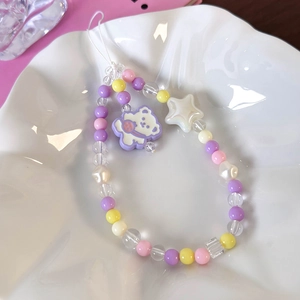 Detail of colorful beaded phone strap with purple bear pendant and white star bead charm