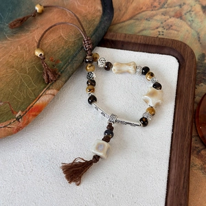 Dettaglio del bracciale di perline intrecciato a mano con pietre occhio di tigre