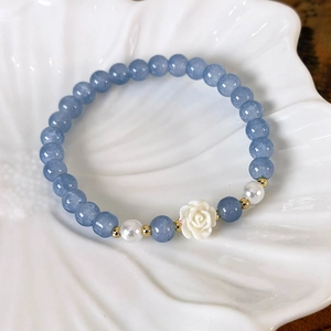 Detailansicht von blauen Kristallperlen mit weißer Kamelie und Perlen in Keramikschale