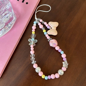 Macro detail of macaron beaded phone charm with pastel butterfly and bow pendants