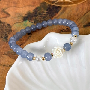 Details von meerblauen Kristallen, Perlen und Kamelienblüten-Charm am Armband