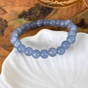 Makroaufnahme von meerblauen Kristallperlen Armband auf einer weißen Keramikschale