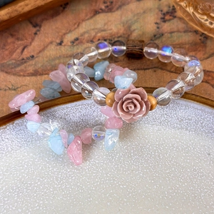Pink resin rose and iridescent beads with pastel stone chip bracelets in white bowl