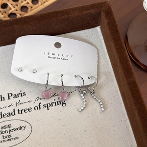 Detalle de pendientes de corazón rosa y broches de diamantes en tarjeta joya