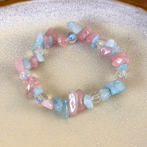 Detail of pink and light blue crushed stone beaded bracelet on a ceramic tray