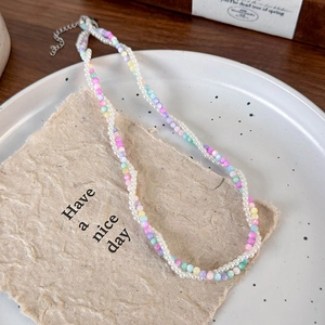 Close-up of double-layered beaded necklace with pearls and colorful macaron beads