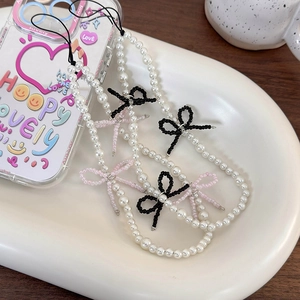 Detail of Korean bow pearl phone strap charm with pink and black beaded accents