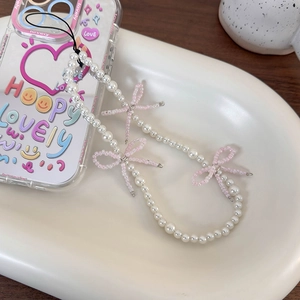 Beaded pearl phone charm with pink bows on a clear case, sweet Korean style accessory