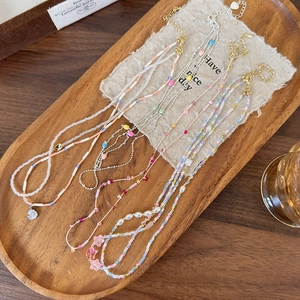 Collana di perline colorate fatta a mano con ciondoli a stella e fiori su vassoio