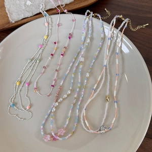 Set di collane di perline estive colorate con stelle e perle su piatto di ceramica