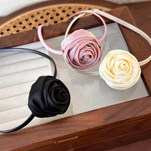 French vintage satin rose choker in black, pink, and beige on a wooden jewelry box