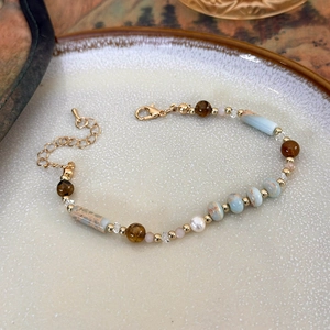 Détail d'un bracelet artisanal avec perles d'eau douce et pierres naturelles sur céramique