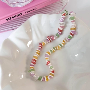 Détail du collier de plage bohème avec perles de gravier colorées et touches de coquillage