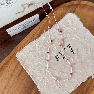 Dettaglio della collana fatta a mano con perline colorate, stelle, fiori e chiusura dorata