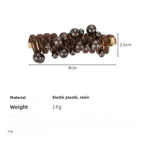 Detail view of brown spiral telephone wire hair tie with grey metallic beads